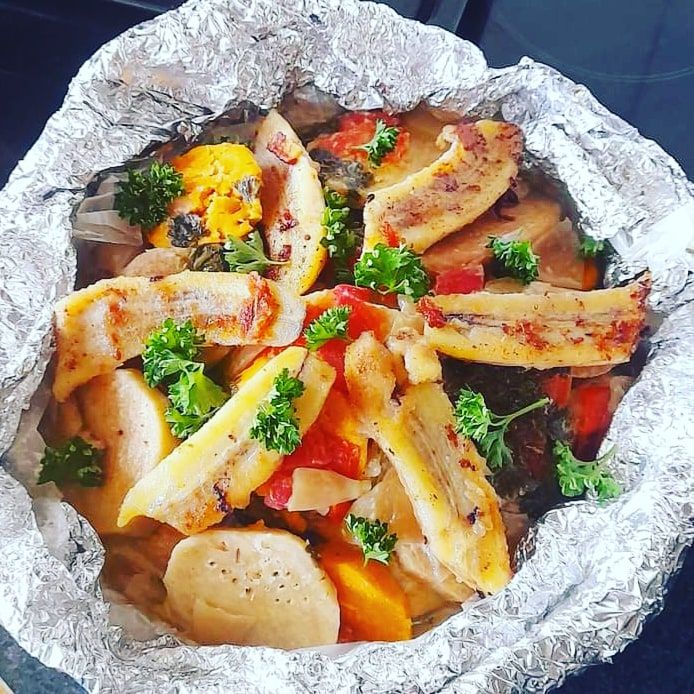 Bougna plat emblématique de Calédonie Il est composé de différents tubercules tels que l'igname, la patate douce et le taro, avec du poulet, du poisson ou des crevettes cuites au four avec des feuilles de bananier et du lait de coco.